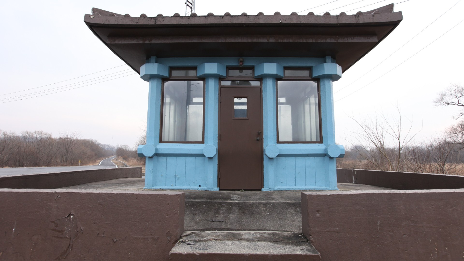 Landscape view of the blue UN Command conference huts straddling the Military Demarcation Line at Panmunjom in the Korean DMZ.