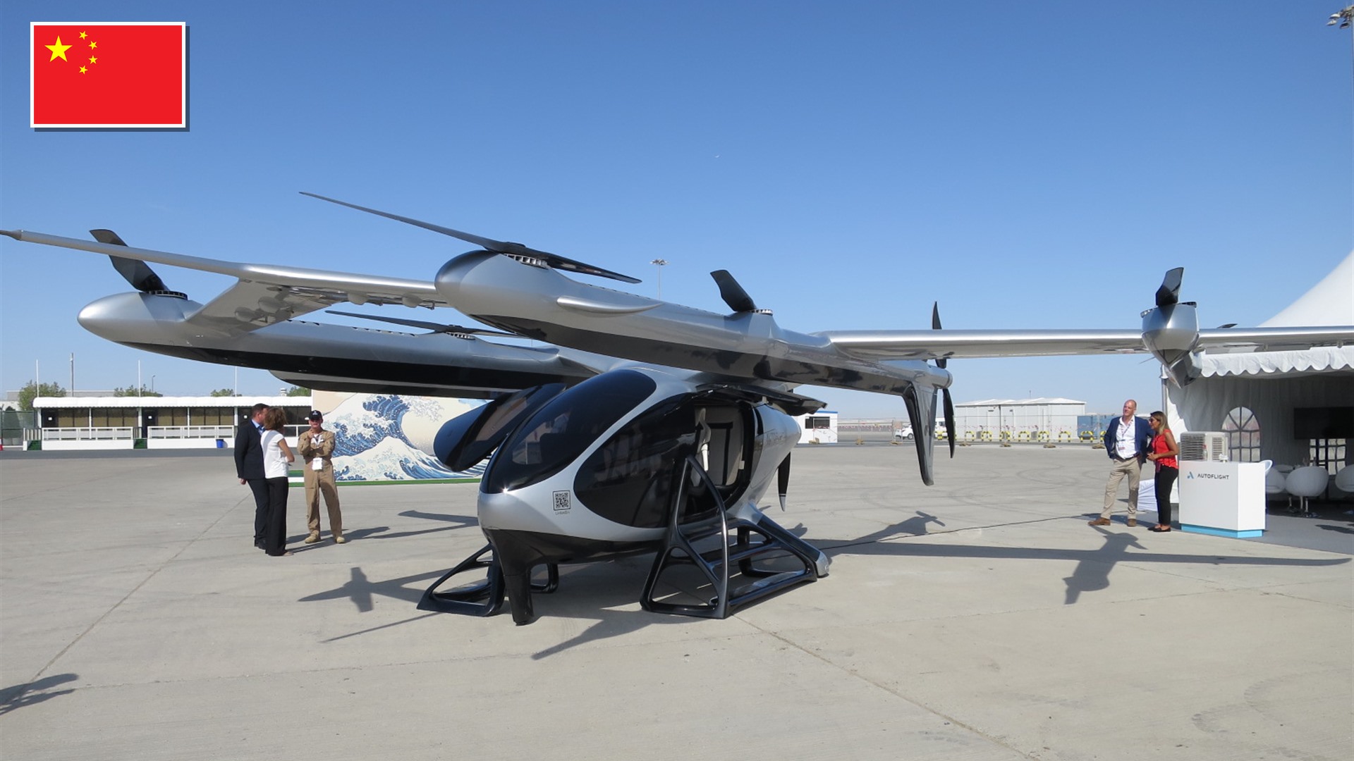 AutoFlight Prosperity lift-and-cruise eVTOL aircraft at Dubai Airshow 2023 with the flag of China in the top-left corner.