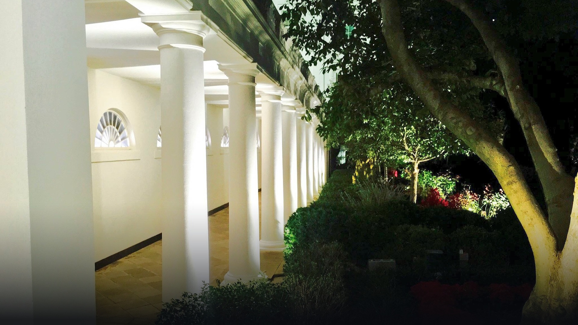 The White House West Wing colonnade illuminated at night.