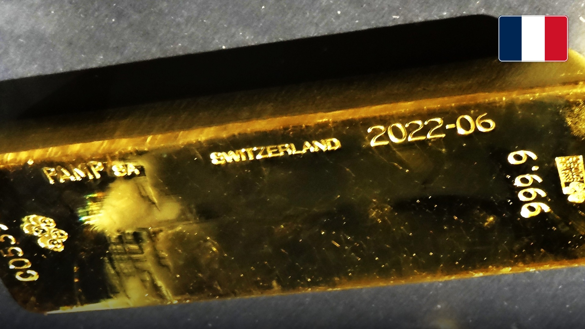 Official 999.9 fine gold bullion bar on display at the Banque de France headquarters in Paris. Official national flag badge in top right.