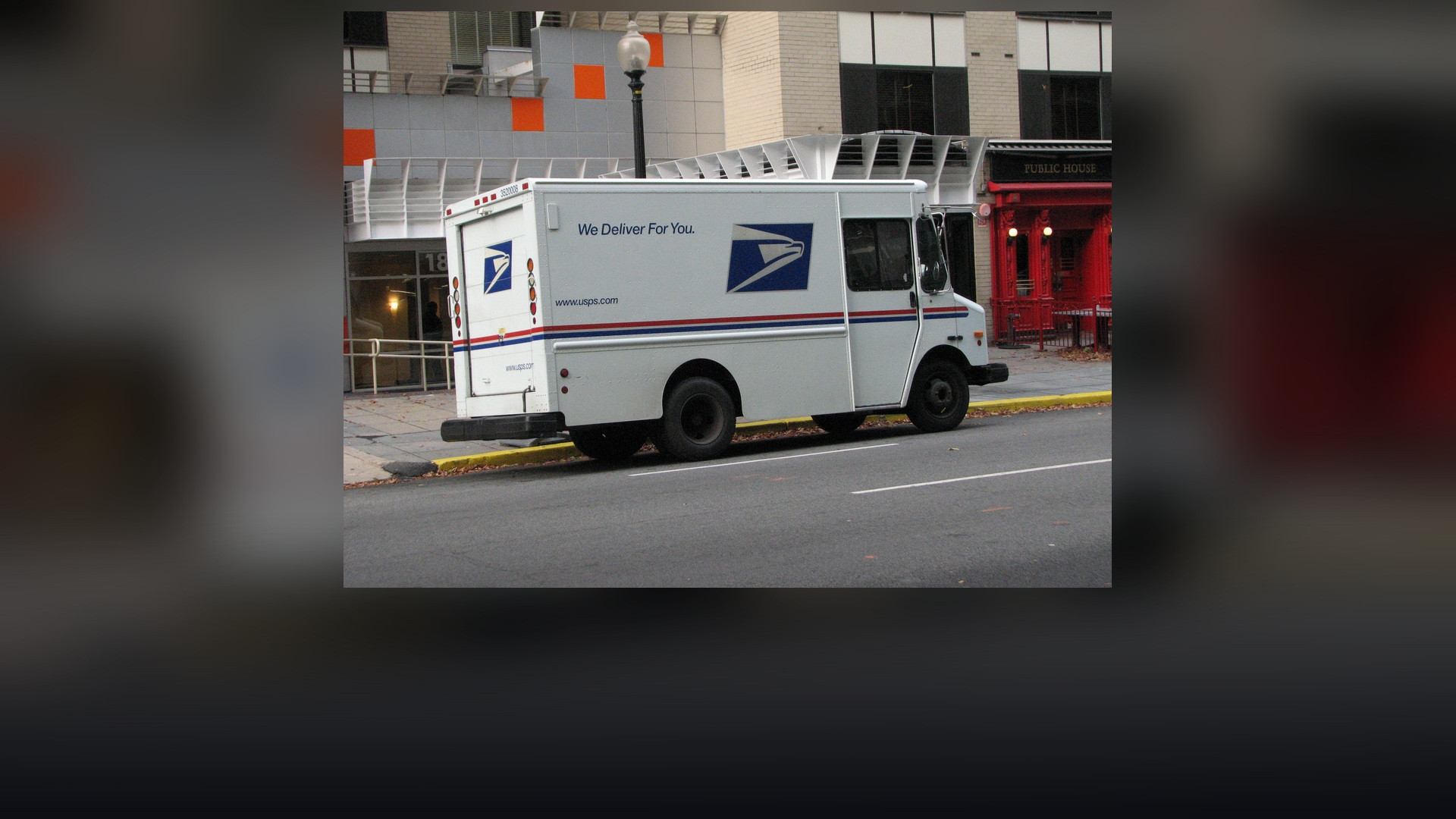 United States Postal Service delivery carrier vehicle in service on city streets.