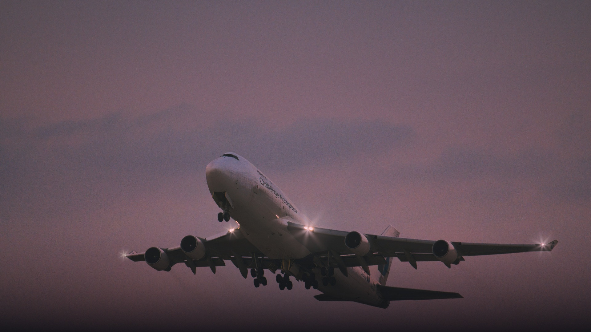 Passenger airliner banking through golden clouds at sunset in smooth flight.