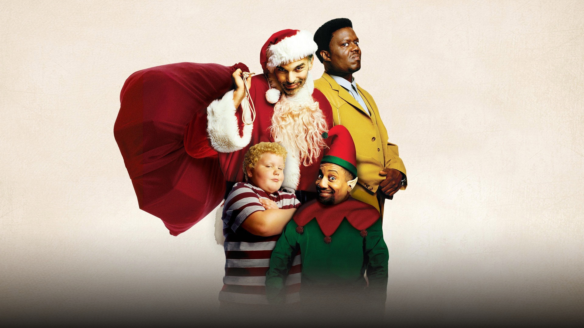 Billy Bob Thornton dressed in a scruffy Santa Claus costume flanked by Tony Cox as an elf and Bernie Mac in Bad Santa.