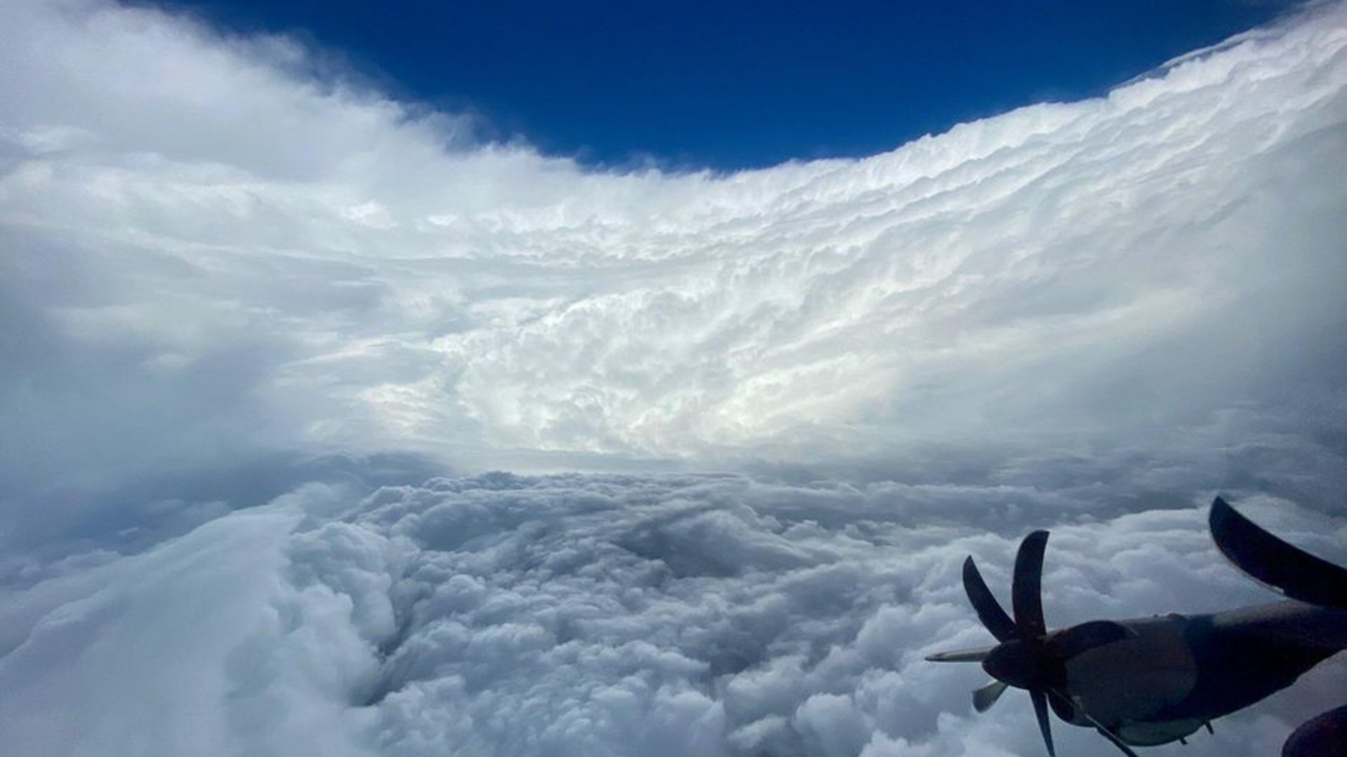Reconnaissance aircraft view inside the towering stadium-effect eyewall of a major cyclone.