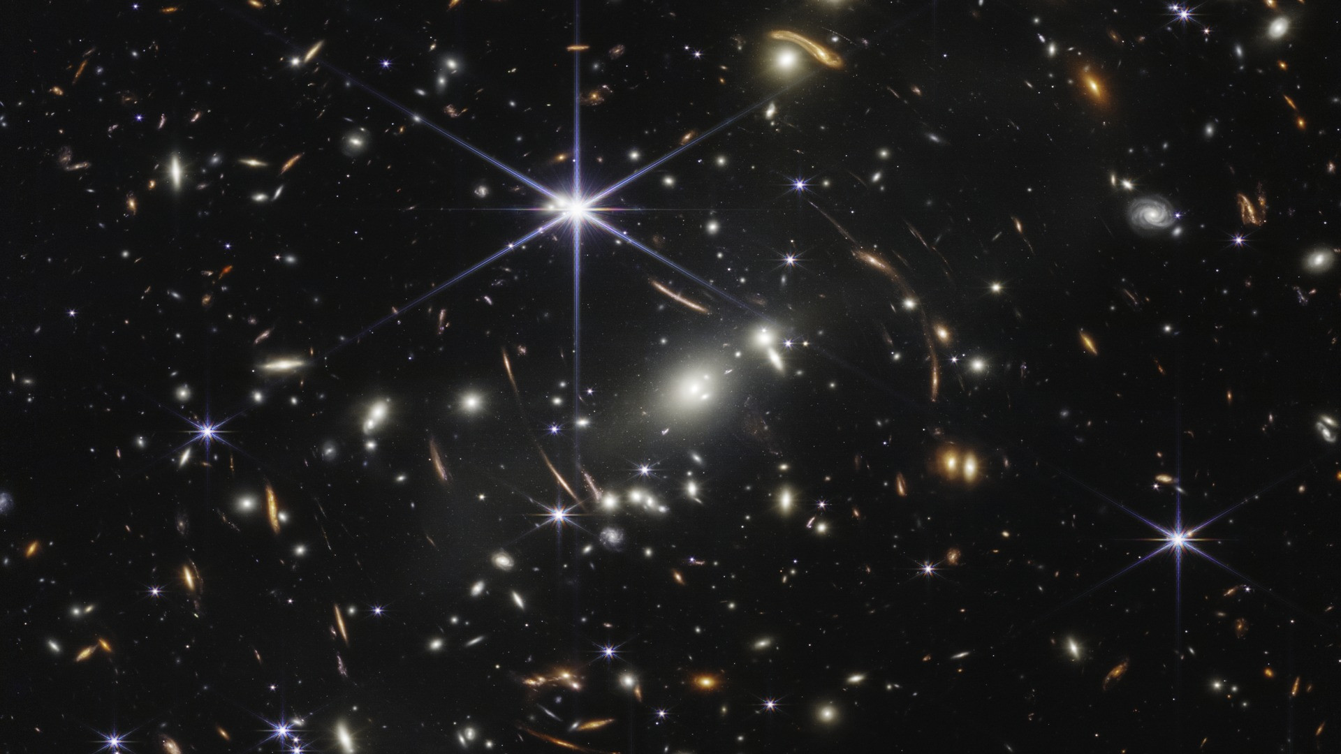 Webb's First Deep Field showing gravitational lensing around massive galaxy cluster SMACS 0723.