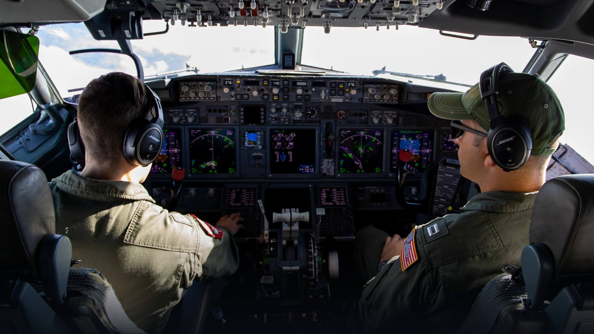 Aviation cockpit flight deck showing pilots wearing communication headsets.