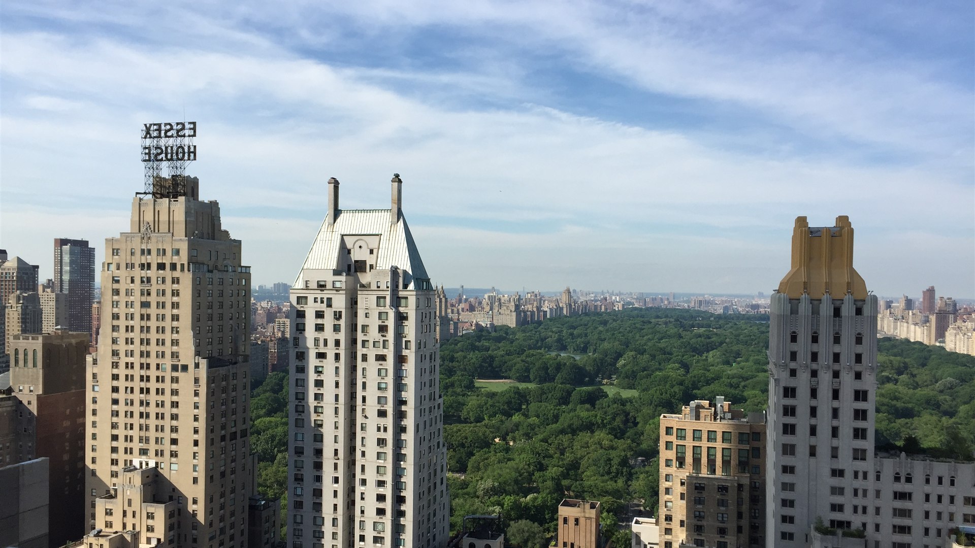 Aerial view of Central Park's green canopy surrounded by Manhattan skyscrapers