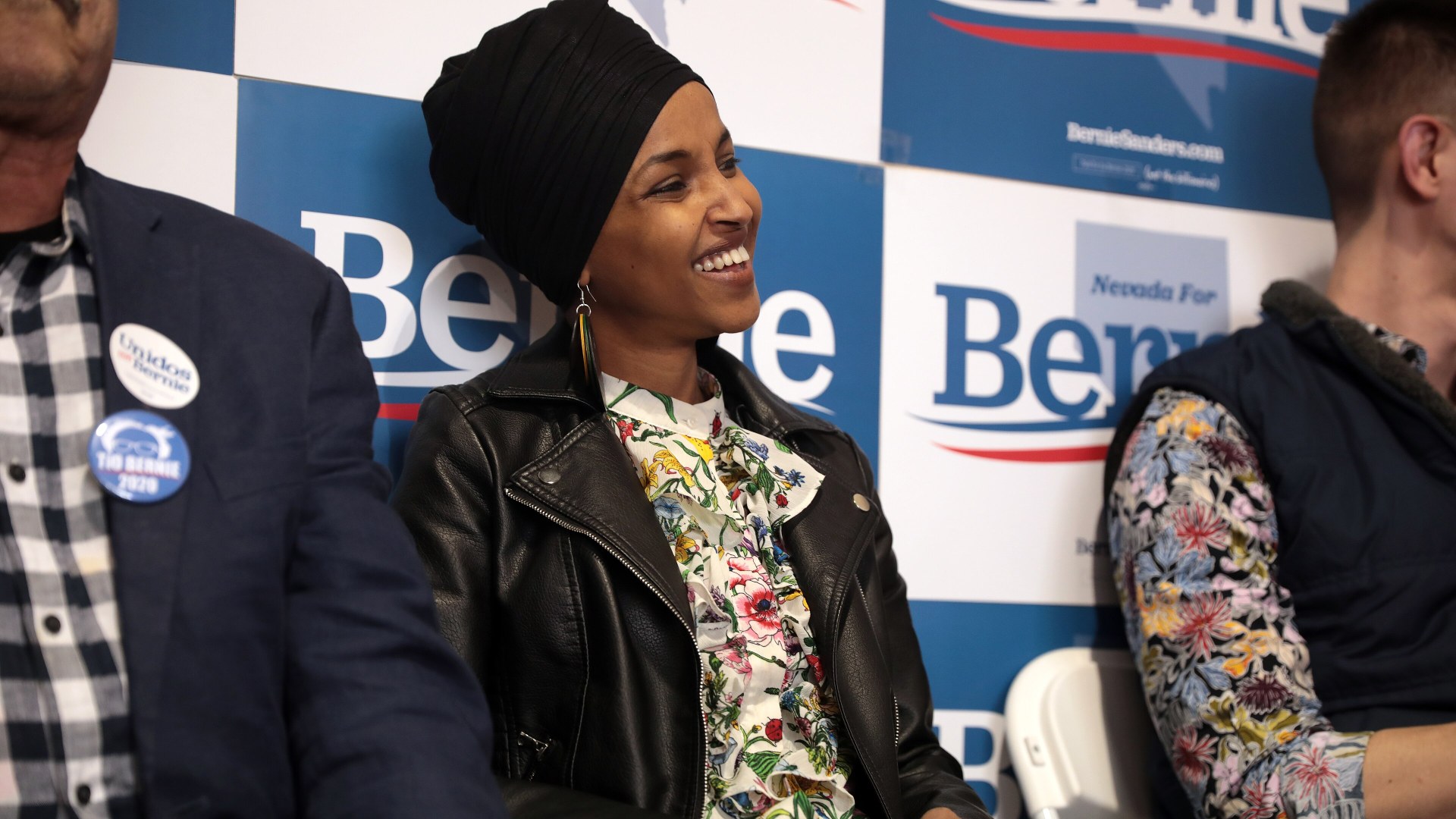 Rep. Ilhan Omar smiling wearing a headscarf at a town hall event