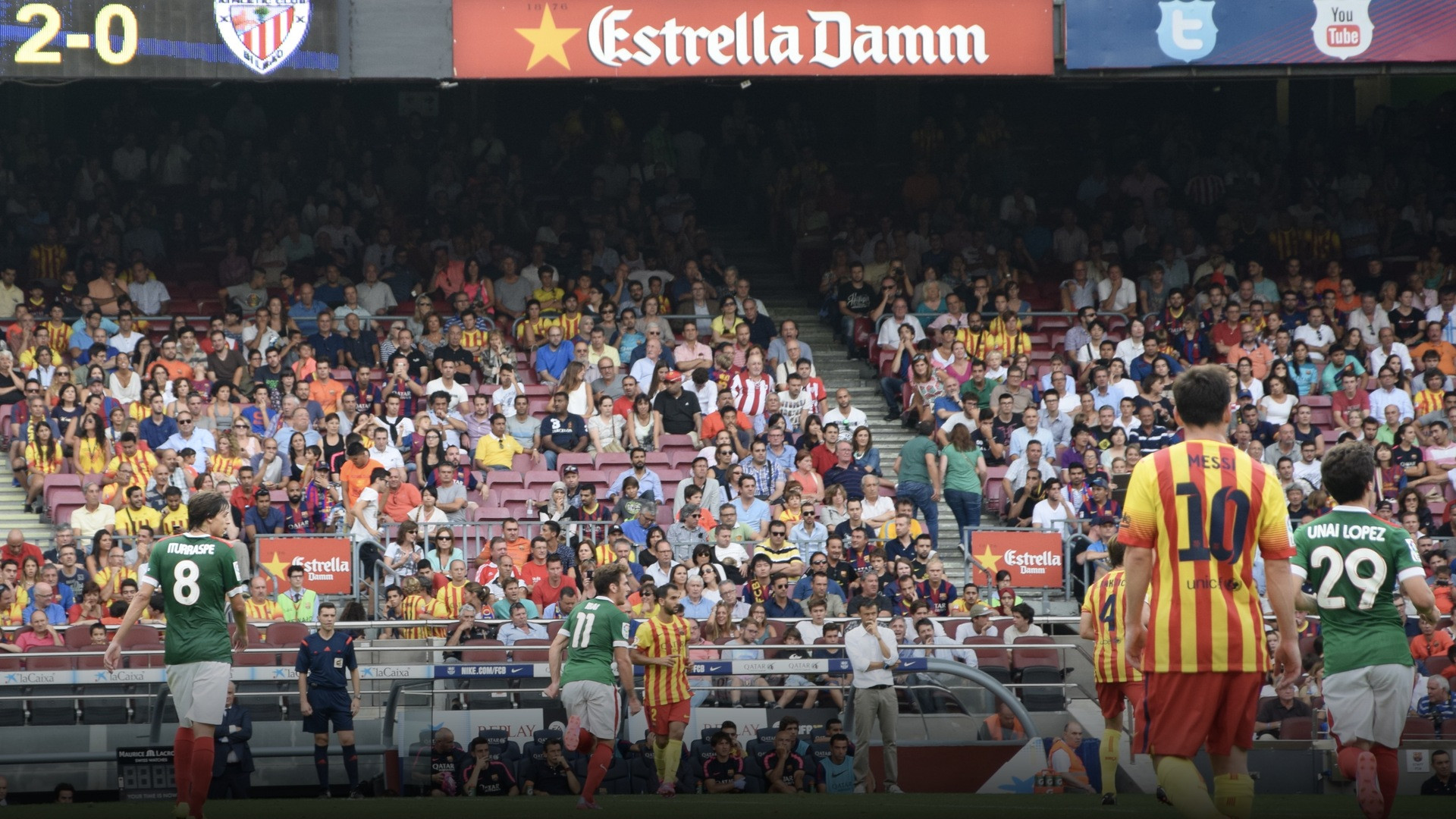 Lionel Messi striking the ball during a competitive match under the floodlights at Camp Nou.