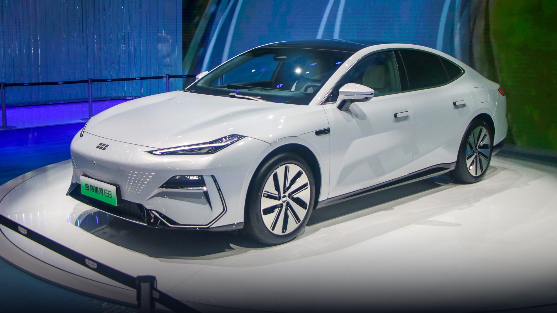 Silver Geely Galaxy E8 electric fastback sedan with aerodynamic profile at Guangzhou Auto Show.