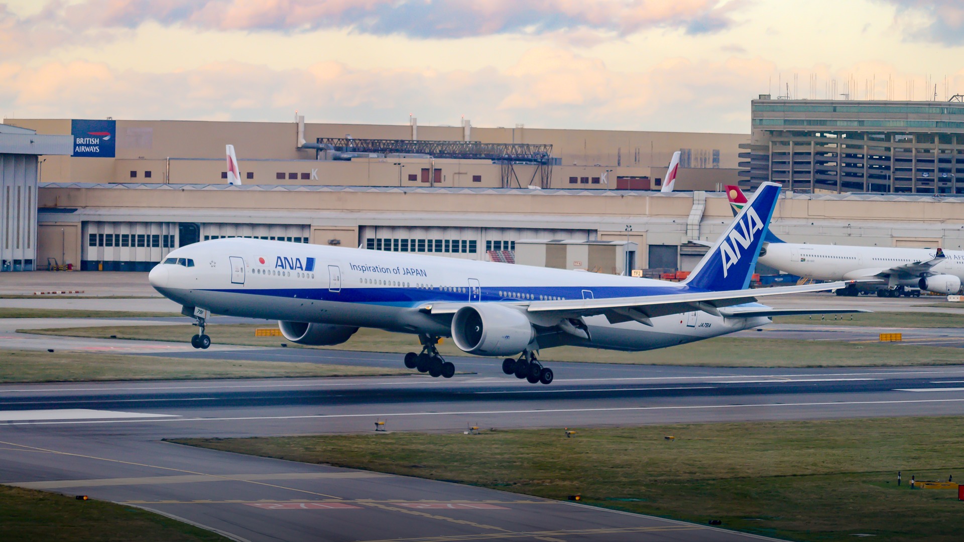 An All Nippon Airways Boeing 777-300ER widebody jet banking smoothly over London Heathrow.