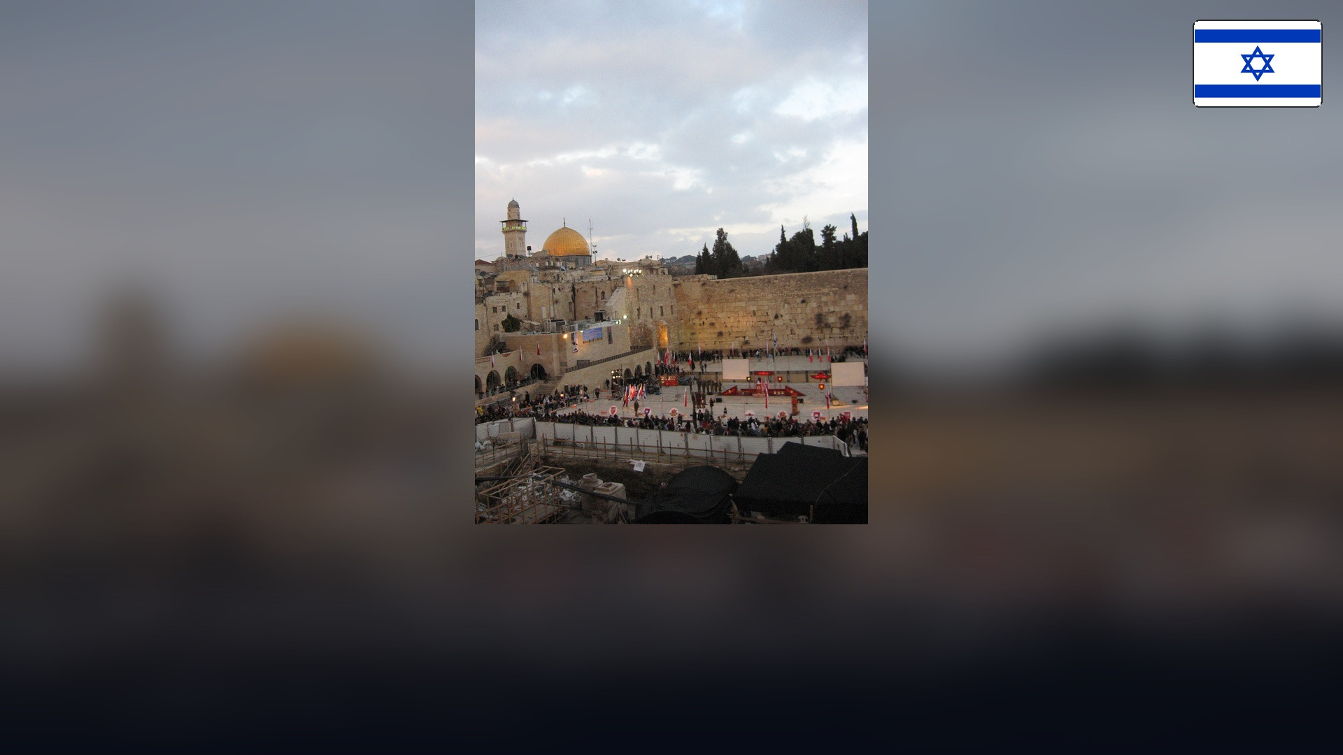Western Wall and Dome of the Rock in Jerusalem with the Israeli flag in the top right corner.