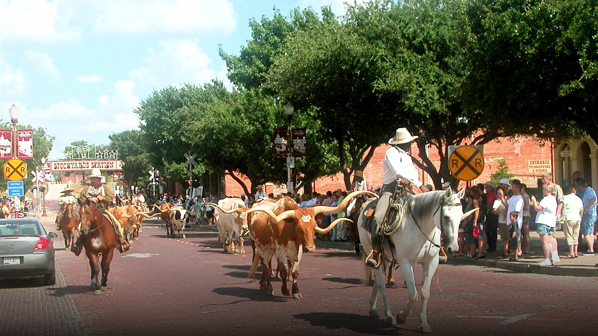 Mounted cowboys wearing traditional cowboy hats and boots at the historic Fort Worth Stockyards.