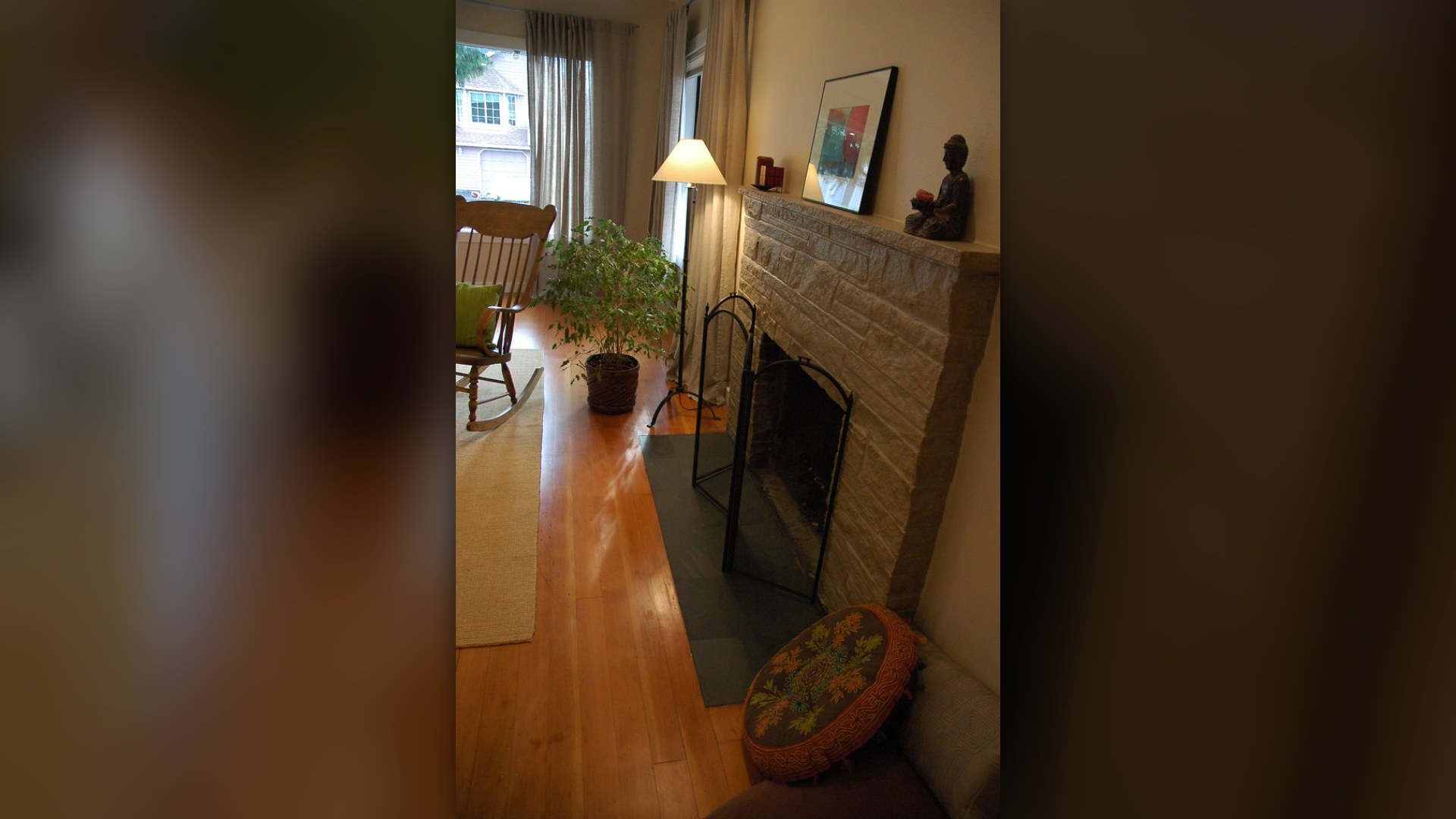 Zen-style living room makeover with painted fireplace, rocking chair, and ficus plant