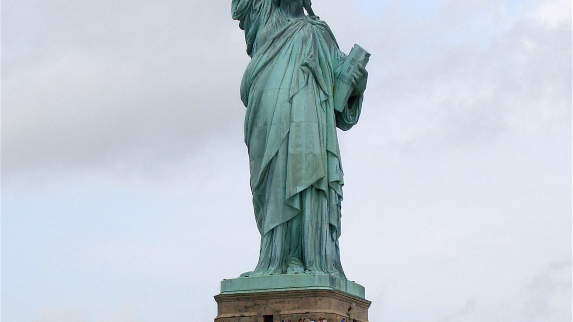 Close-up of the Statue of Liberty torch and crown against a blue sky