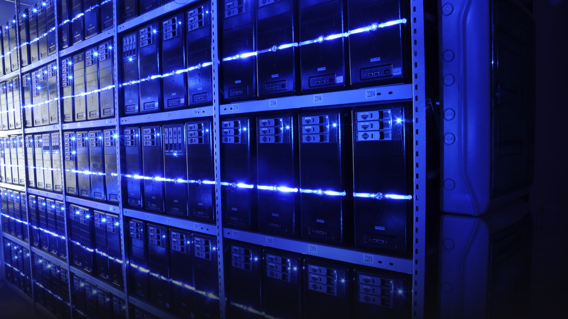 Illuminated high-tech datacenter aisle with blue LED lights lining rows of running enterprise servers.