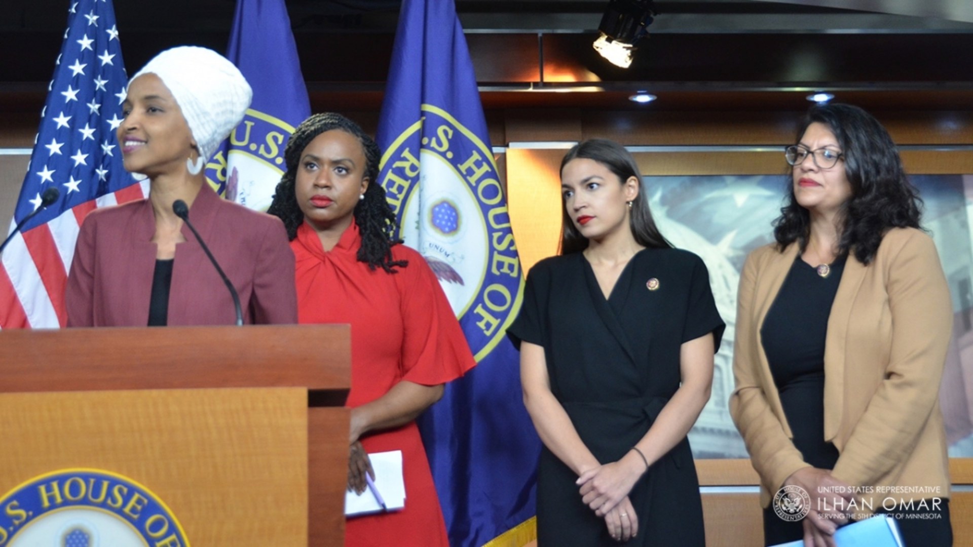 Rep. Ilhan Omar speaking at a Capitol Hill press conference alongside Ayanna Pressley, Alexandria Ocasio-Cortez, and Rashida Tlaib