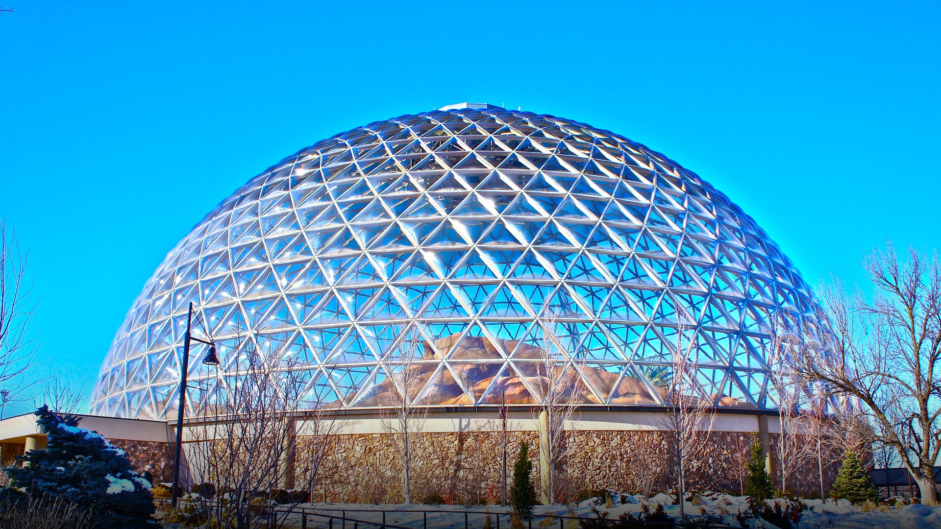 The massive geodesic glazed Desert Dome structure at Omaha's Henry Doorly Zoo under a bright blue sky.
