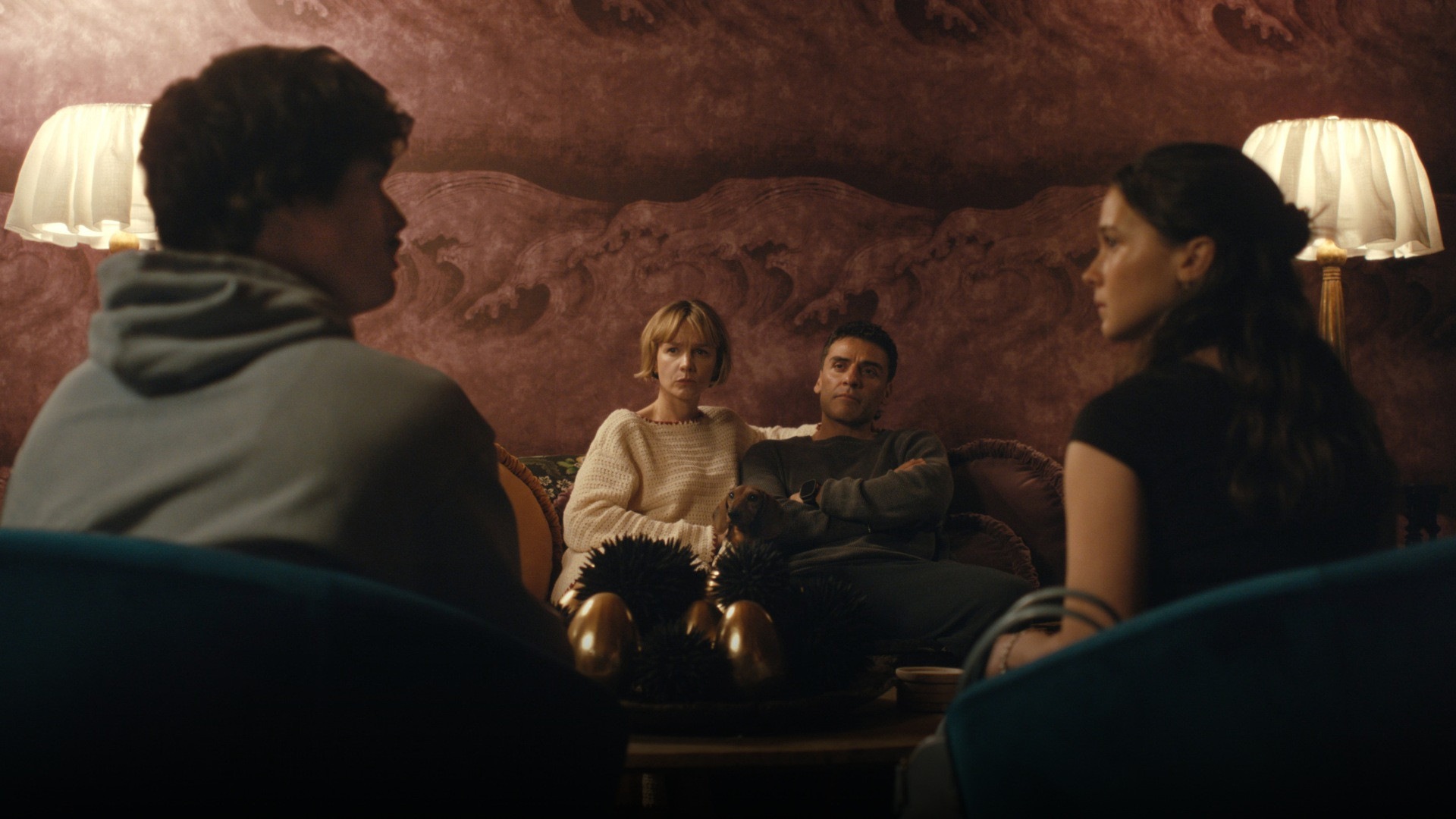 Oscar Isaac and Carey Mulligan seated on a sofa engaged in tense confrontation.