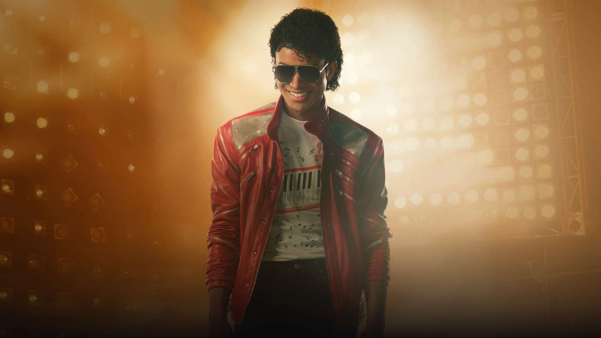 Jaafar Jackson as Michael Jackson performing on stage under dramatic concert spotlight illumination.