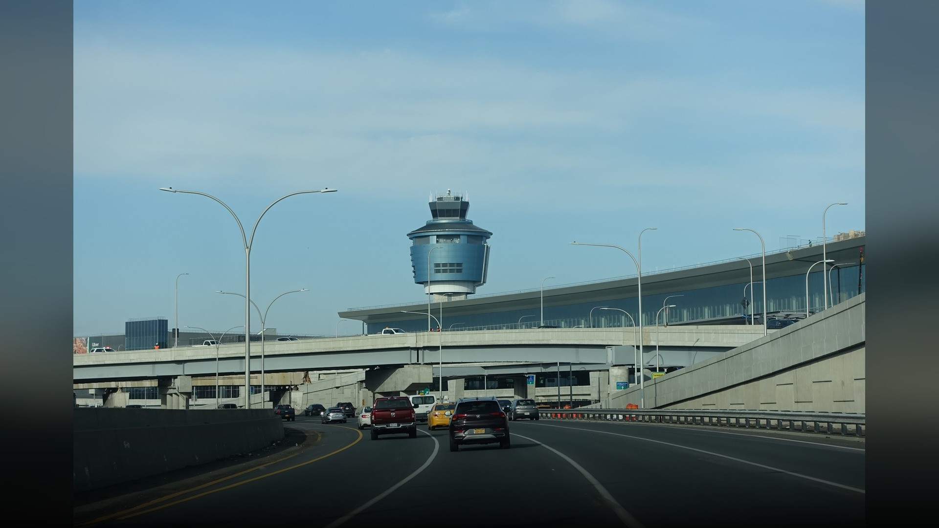 The gleaming glass facade and pedestrian skybridges of the new Terminal B at LaGuardia Airport in New York.