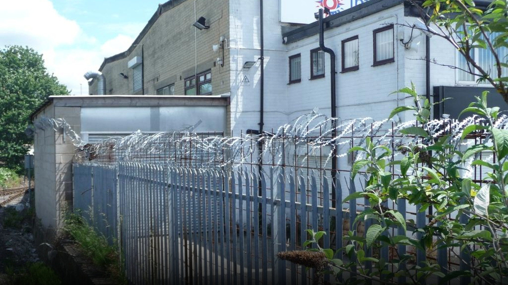 Heavy perimeter security fencing with multiple sharp loops of concertina razor wire.