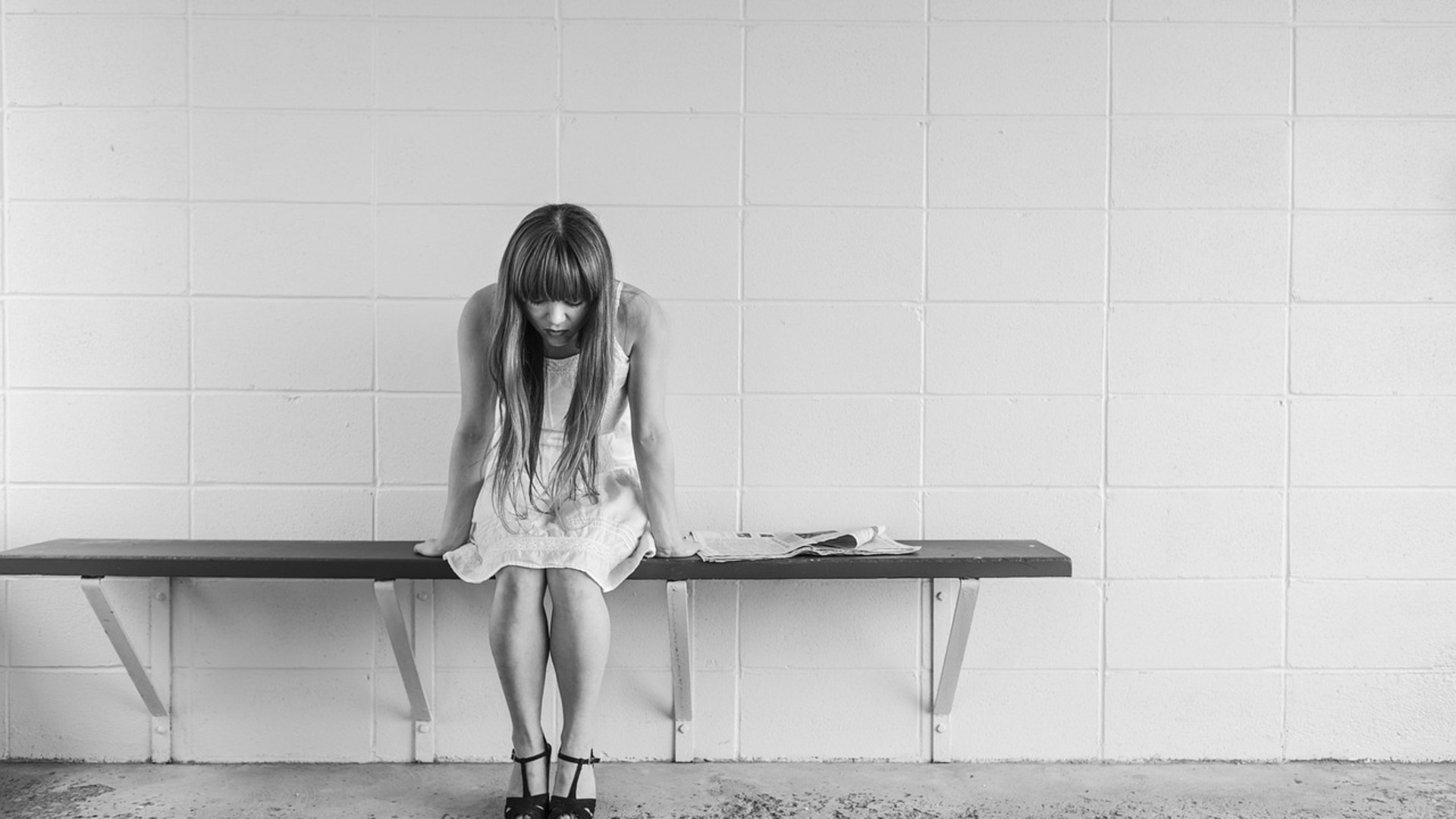 Woman sitting alone on a bench waiting for someone who did not show up