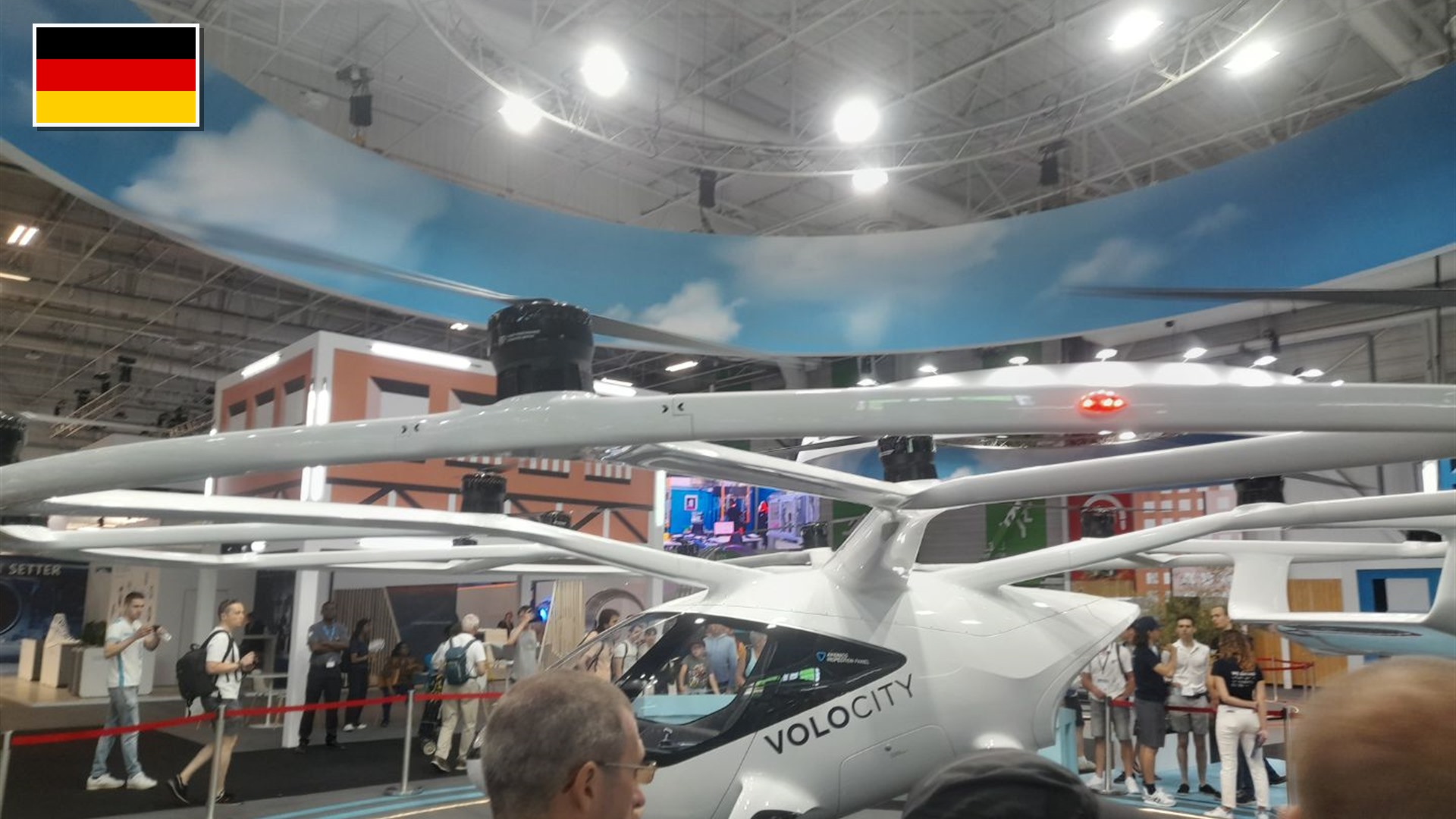 Volocopter VoloCity 18-rotor electric air taxi at the Paris Air Show with the flag of Germany in the top-left corner.
