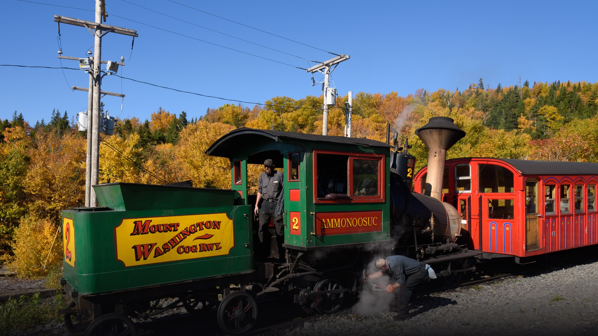 Mount Washington Cog Railway vintage locomotive ascending steep mountain tracks on the summit approach.