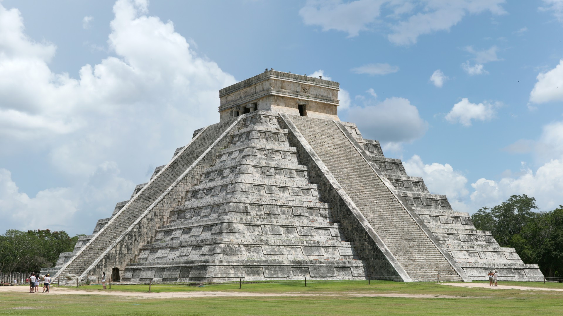 The ancient stepped stone pyramid of El Castillo at Chichen Itza under a bright Mexican sky.