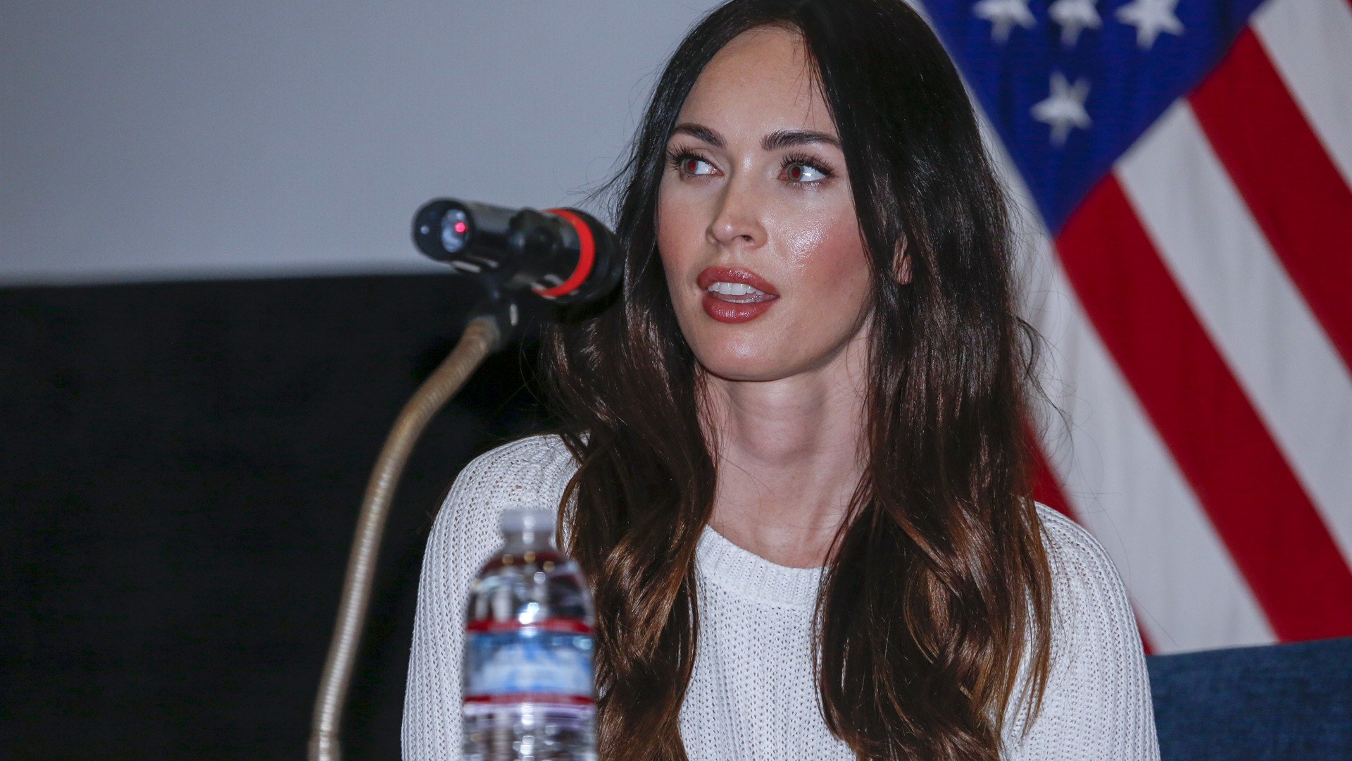 Megan Fox addressing an audience at a press conference in South Korea.