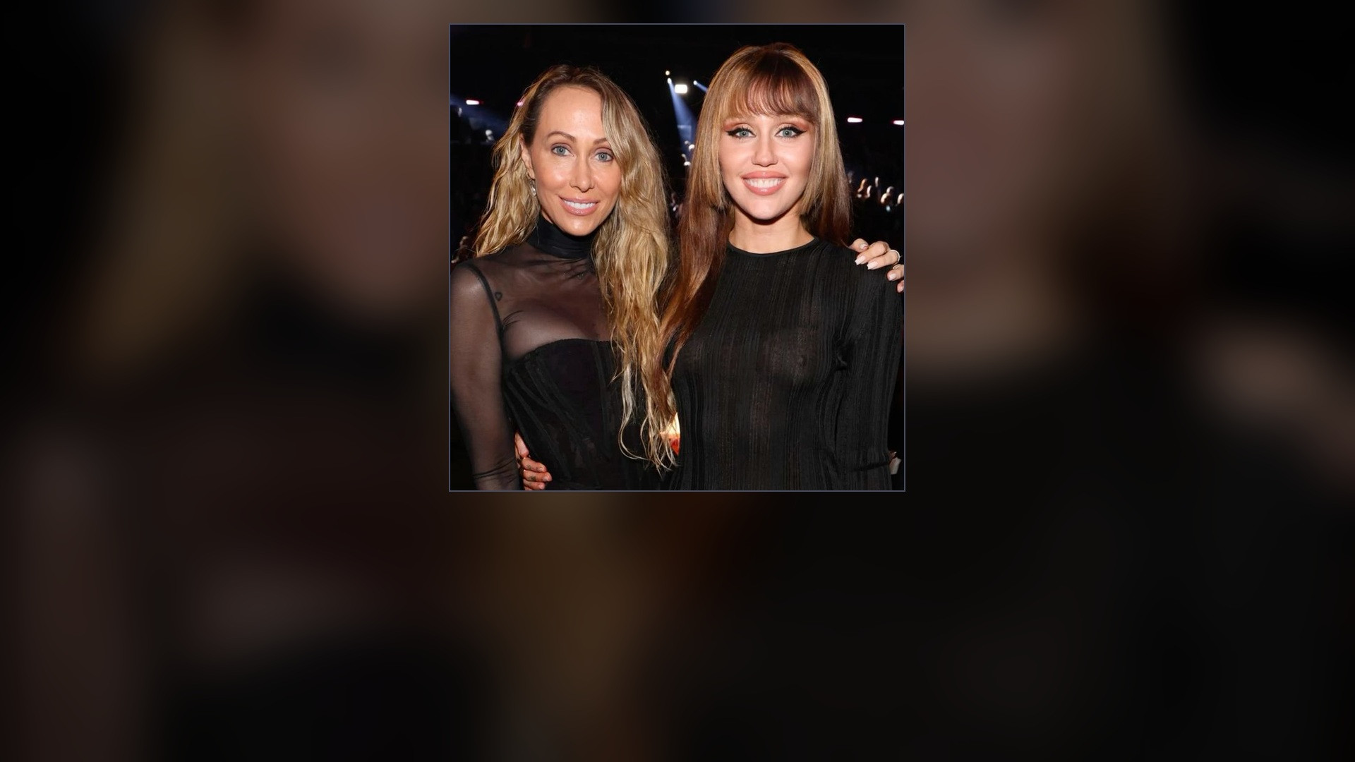 Tish Cyrus embracing daughter Miley Cyrus at an awards ceremony.