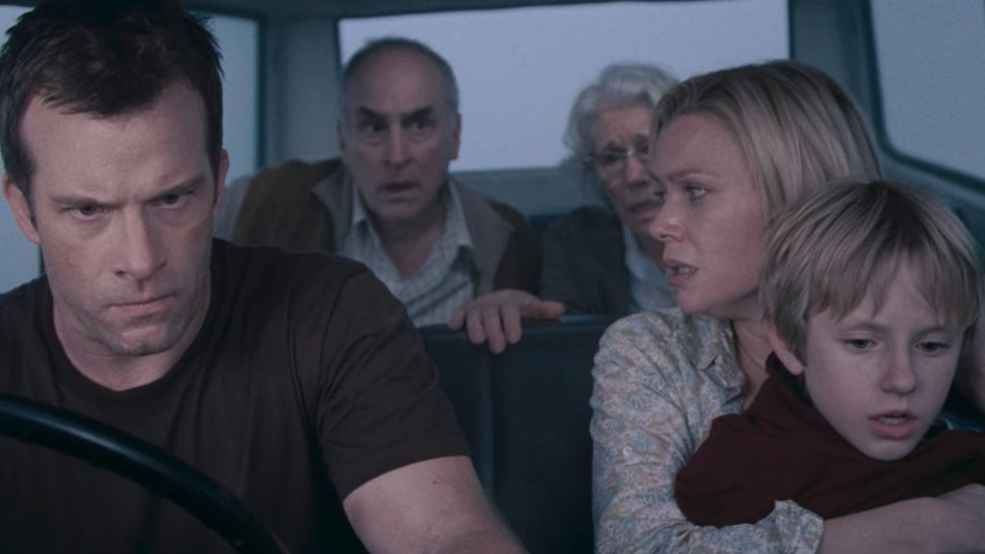 David Drayton comforting his frightened son in a mist-shrouded vehicle, image horizontally flipped.