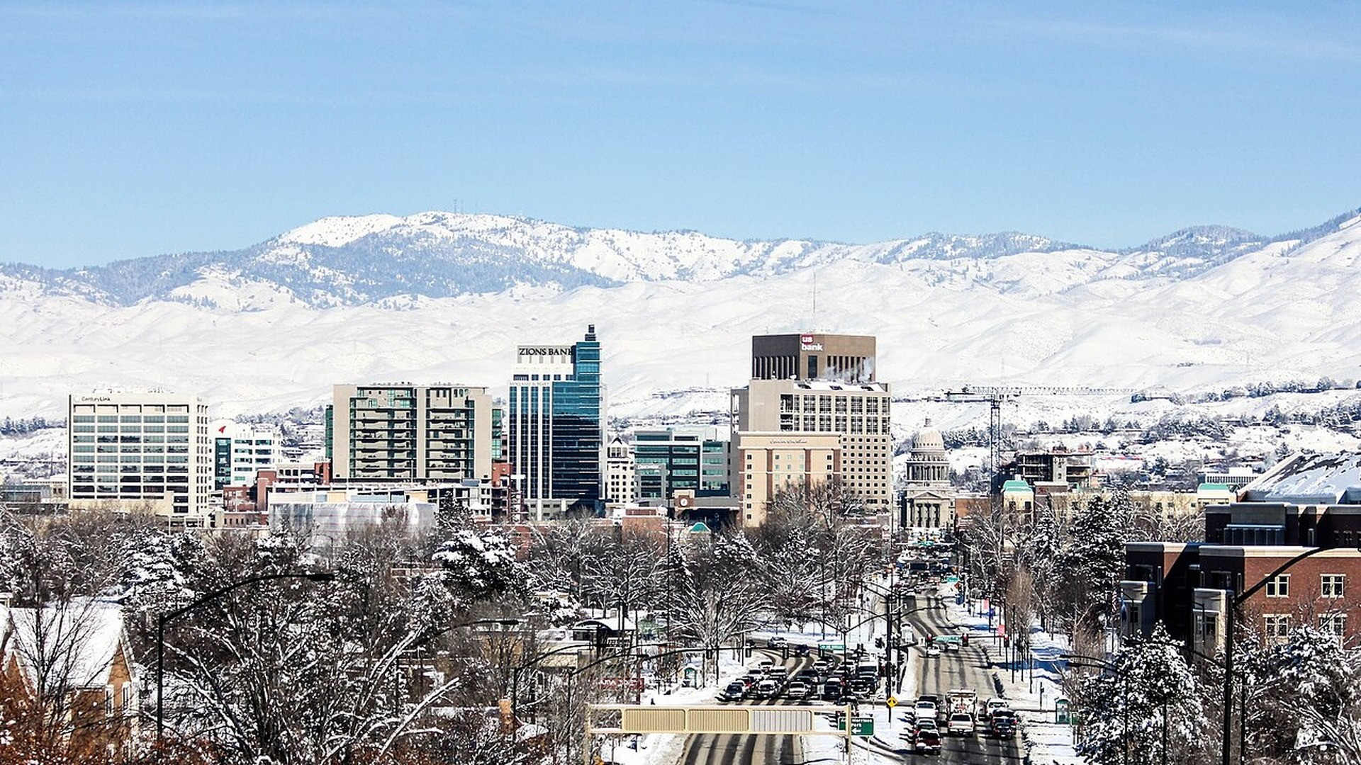 Idaho State Capitol dome rising majestically against tree-lined downtown Boise.
