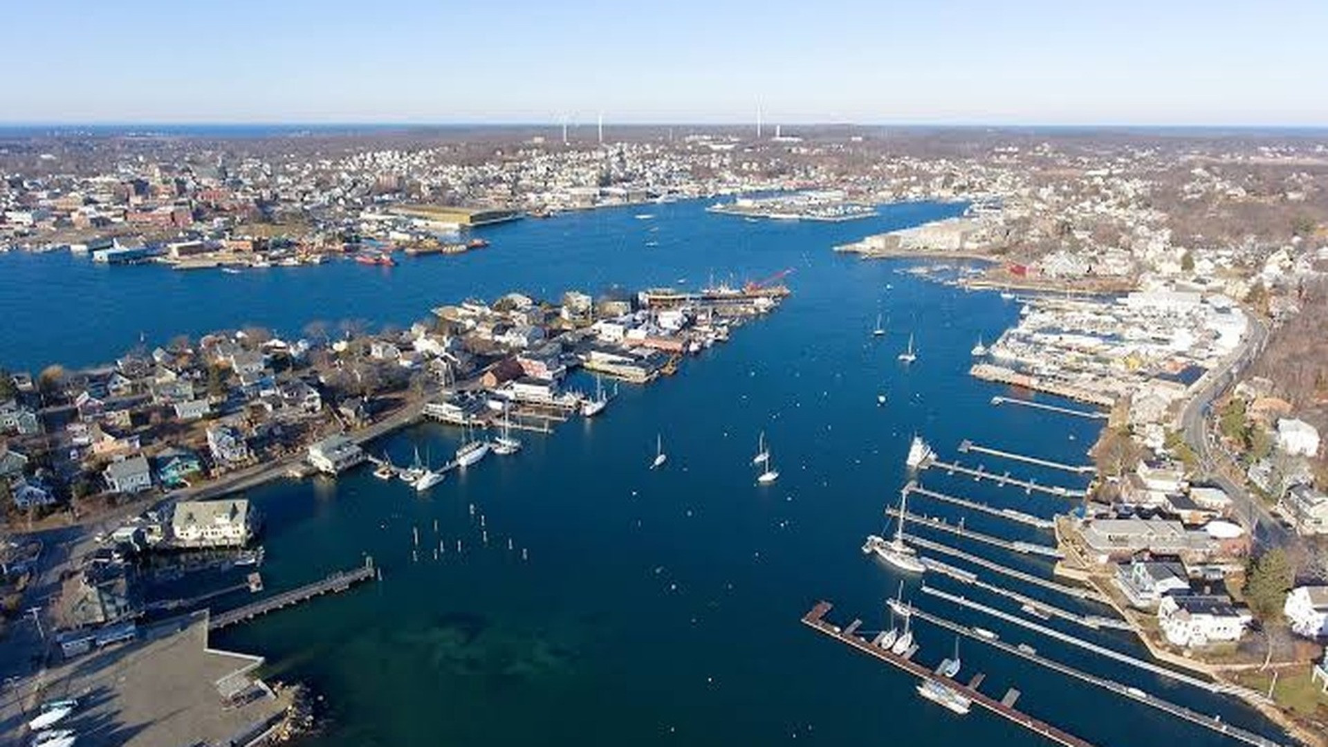Historic Gloucester harbor filled with working lobster boats and granite coastal shoreline.